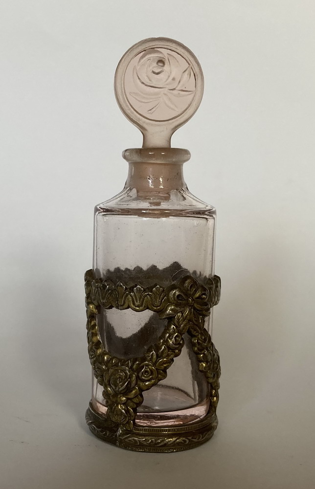 Pink glass perfume bottle  in brass stand.